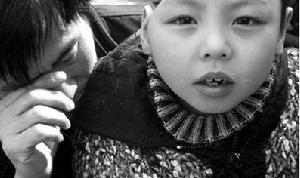 2009年3月13日在海淀區北京三博腦科醫院門外，“半腦”男孩依偎在父親懷裡。男孩父親介紹，兒子患有Rasmussen's腦炎，在醫院做了多次手術。