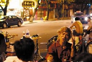 微閉著眼，與冬粉拉著手，炒螺明邊唱歌，邊在回答著別人對他的各種問題