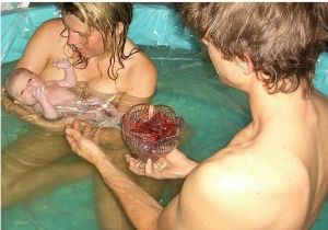   Lotus 水中分娩，丈夫手中玻璃碗內是胎盤，臍帶還連著新生兒和胎盤。--------------------------------------------------------------------------------