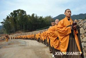 3月25日，上百位僧人敲著木魚、誦著經文前往茶園。