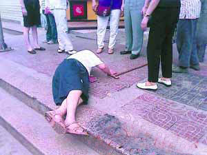 老人臉朝下倒在人行過道上，一根拐杖丟棄在一邊，旁邊是七八個圍觀者猶豫的腳。 