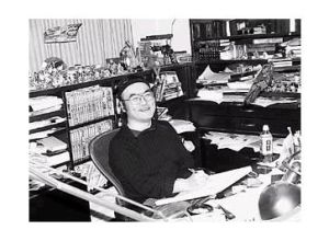 青山剛昌坐在工作檯前