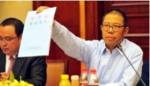 農夫山泉股份有限公司董事長鍾睒睒在新聞發布會上展示有關部門出具的同批次產品的檢驗合格報告