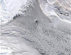在揚馬延島產生的島嶼效應影響下，格陵蘭海上空的平行雲街內正形成壯觀的卡門漩渦。與其他圖片中的島嶼一樣，揚馬延島也在干擾氣流，導致流動的雲層在尾流處形成反向漩渦。這幅照片由宇航局Aqua衛星的MODIS於2009年2月拍攝，格陵蘭島海岸和突出的海冰出現在照片的左上方。