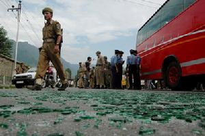 2007年7月29日，在印控克什米爾夏季首府斯利那加的爆炸現場，警察從被損壞的旅遊巴士旁走過。當日，一輛旅遊大巴在斯利那加發生爆炸，造成至少5人死亡，19人受傷。