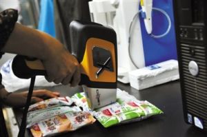 實驗人員先用手持X螢光能譜儀檢測袋裝牛奶包裝。 