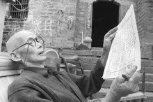 一位對著手抄簡譜《八月桂花遍地開》的老人