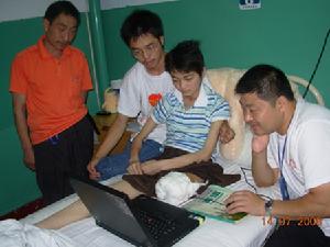 許漣鋼（右一）和他的援助團隊在汶川地震災區為受傷致殘的少女秀秀（右二）進行心理援助