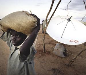 查德，逃離蘇丹達爾富爾衝突的難民站在救援工作者使用的衛星天線旁邊