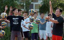 趙祝勝(右)在為學生做發球示範動作