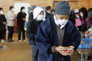 2011年3月18日，在日本宮城縣氣仙沼市的一處避難所，日本老人手拿速食麵作為午餐。