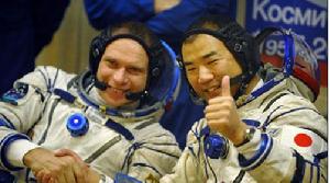 俄羅斯太空人奧列格&middot;科托夫（左）和日本太空人野口聰一在對太空衣進行測試後做手勢