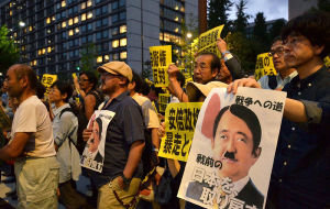 2014年6月30日，日本示威者在安倍官邸外集會，手舉標語牌抗議安倍政府試圖解禁集體自衛權。