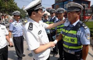 　8月3日，武漢市交管局政委王斌在為交警擦汗　武漢交管局供圖