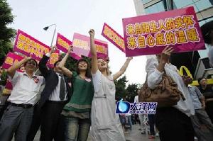 許多西裝革履的“抱抱團”成員手舉醒目標語，向來往的行人“爭取擁抱”