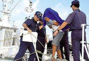 8日，被蒙著面、戴上手銬的船長詹其雄被日本巡邏船押至沖繩縣石垣港