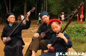 廣西龍州縣金龍鎮板池屯１０歲的黑衣壯族小姑娘李秋燕在爸爸和奶奶的指導下學彈天琴。