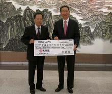 孫總領事接受梁冠軍先生（左一）的捐款