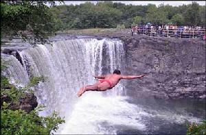 在牡丹江鏡泊湖吊水樓瀑布景區，一名勇士為觀眾表演懸崖跳水