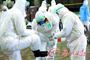在福島核電站外，工作人員在互相檢測工作服上的核輻射量。