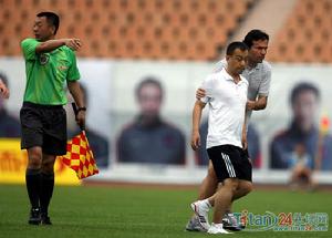 青島球迷衝進場地欲打裁判。保全帶走球迷。