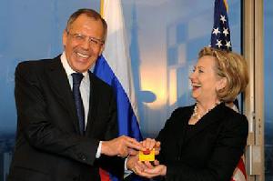 （圖）3月6日，在瑞士日內瓦，美國國務卿希拉蕊·柯林頓（右）與俄羅斯外長拉夫羅夫在出席雙邊會談時同時按下一個紅色按鈕。這個有紅色按鈕的小裝置是希拉蕊送給拉夫羅夫的禮物。按鈕上方寫有俄文“負擔過重”，下方寫有英文“重啟”字樣。