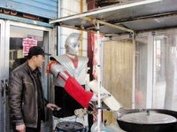 崔潤全演示操作“削麵機器人”