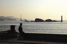 坐碼頭邊的工人背後是曾經繁華的雙嶼港