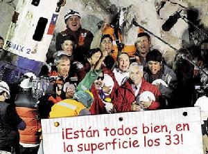 智利《第三報》頭版刊登的照片，為智利總統、第一夫人和獲救礦工的合影，照片下方有個牌子：我們的33人都在地面上了