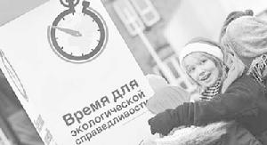 人們在觀看“氣候公正時刻”集會活動的宣傳板