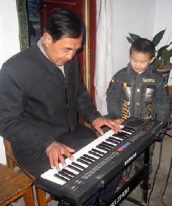 輔導孫子彈琴。