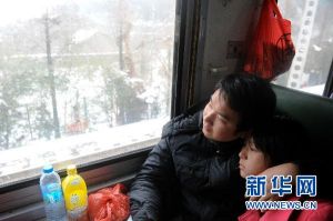L160次列車途經江西九江，一對情侶在觀看窗外的雪景（1月21日攝）。從廣東東莞到江西九江溫度下降了近15攝氏度。新華社記者 郭晨 攝