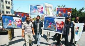 一群支持拉丹的巴勒斯坦人手執拉丹的畫像在遊行。