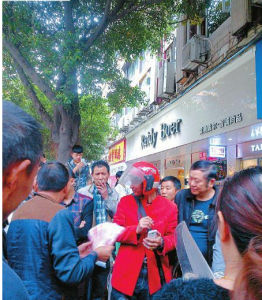 當5000元現金從天而降時，10餘名民眾忙上前撿錢並交給失主