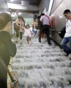 6月23日，在北京捷運4號線陶然亭站內，人們在被雨水沖刷的台階上行走。