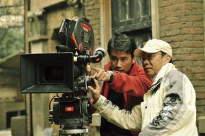 導演柳雲龍和攝影在《東風雨》片場切磋 