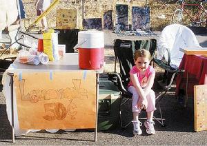 茱莉坐在自己的檸檬水攤位旁邊