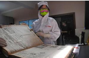 工作人員穿著防塵服對“俄文老檔”進行電子掃描。