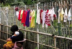 午後陽光衝破潮濕的霧氣，普照大地，街坊曬衫之餘，抱著孩子沐浴陽光