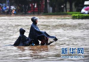 6月15日,南寧市民在嚴重內澇的街頭騎行