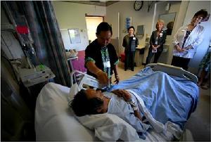 在美國加利福尼亞州默塞德市的莫西醫學中心(Mercy Medical Center)，一位苗族薩滿巫醫正在施行某種儀式，替躺在床上的糖尿病病人治病。